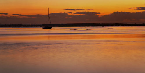 Scenic view of lake against orange sky