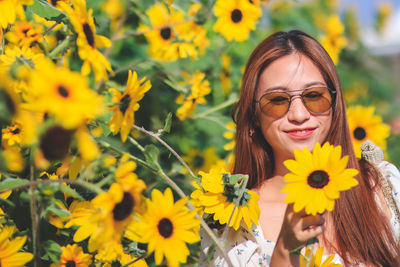 Portrait of smiling woman with yellow flowers