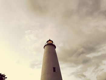 Low angle view of lighthouse by building against sky