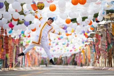 Man jumping under balloons