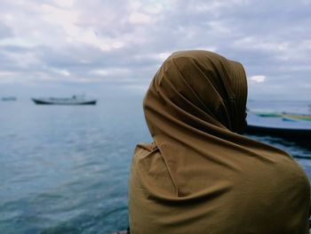 Rear view of woman looking at sea against sky