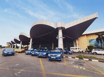 Cars on road against sky in city