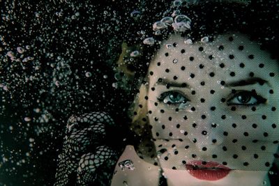 Close-up portrait of beautiful woman looking through net