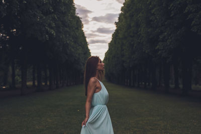 Young woman standing amidst trees