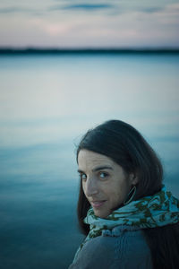 Portrait of smiling young woman by water