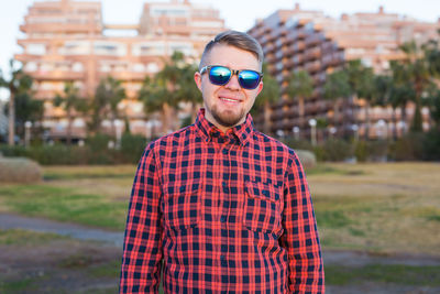 Portrait of young woman wearing sunglasses standing outdoors