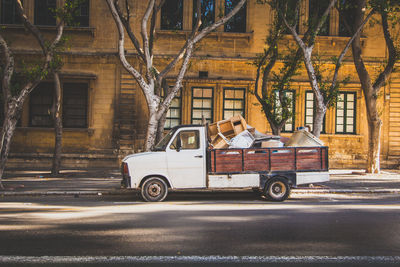 Pick=up truck parked on road against old building