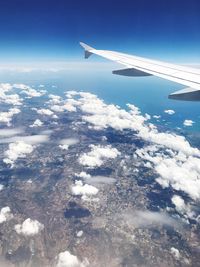 Aerial view of airplane wing against blue sky