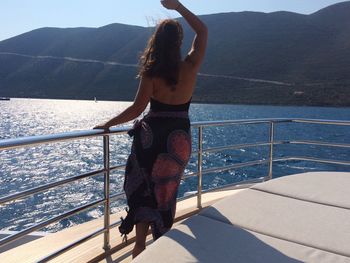 Young woman standing on boat sailing in sea