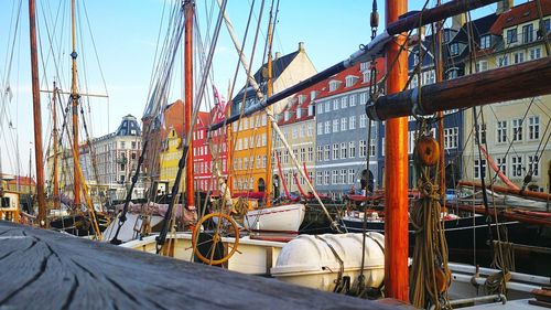 Sailboats moored at harbor against sky