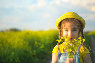 Portrait of young woman holding yellow flower