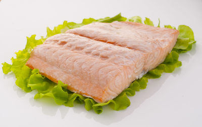 High angle view of fish and bread on white background