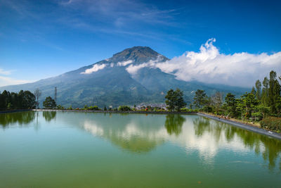 Scenic view of lake and mountains against blue sky