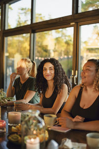 Portrait of smiling young woman with female friends at retreat center