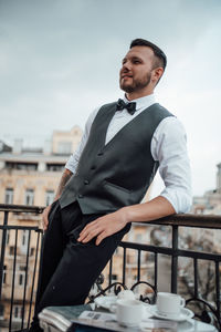 Full length of young man standing against sky