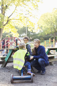 Kindergarten teacher communicating with student on playground