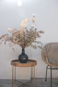 Flower vase on table against wall at home