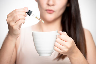 Midsection of woman drinking glass