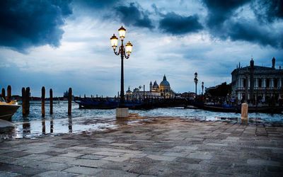 View of street lights in city at waterfront