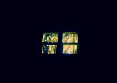 Low angle view of illuminated window in darkroom
