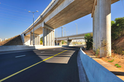 Road by bridge against sky in city