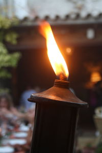 Close-up of lit candle in temple