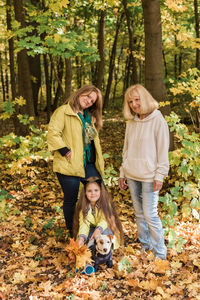Full length of mother and daughter in forest during autumn