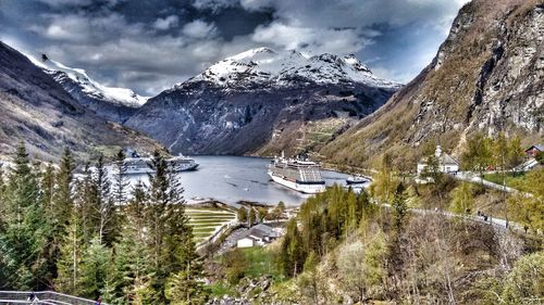 Scenic view of lake and mountains against cloudy sky