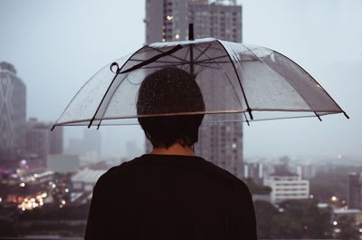 Rear view of man standing against buildings