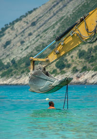 Man on boat in sea against sky
