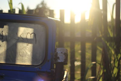 Close-up of abandoned vehicle against fence