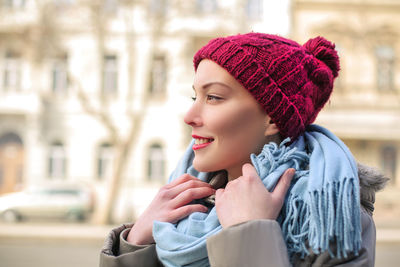 Young woman looking away in city during winter