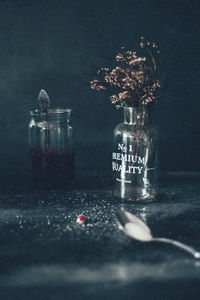 Cranberries in jar by flower vase on table