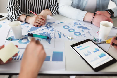 Business planning process with colleagues or partners sitting together at the table with graphics