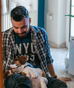 Midsection of man with dog at home