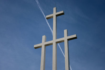 Low angle view of cross against blue sky