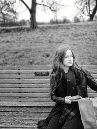 Woman with bag sitting on bench