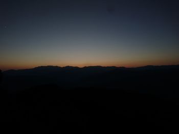 Silhouette landscape against clear sky during sunset