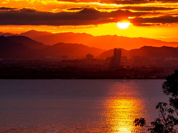 Scenic view of silhouette mountains against orange sky