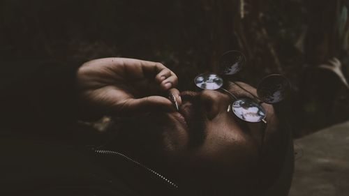  young man lying on floor while smoking