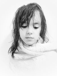 Close-up of girl wrapped in towel against white background