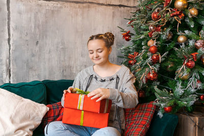 Pensive caucasian girl in home clothes pajamas christmas mood at home