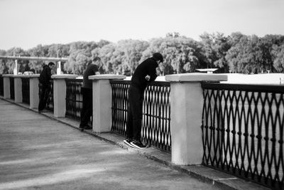 Horses on railing against sky