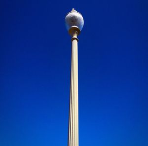 Low angle view of communications tower against blue sky