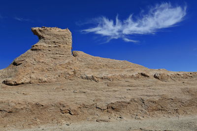 Rock formations on landscape against blue sky