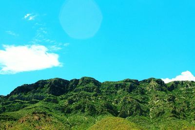 Scenic view of mountains against blue sky