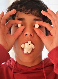 Close-up portrait of child eating marshmallows