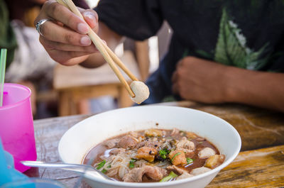 Close-up of man eating food on table