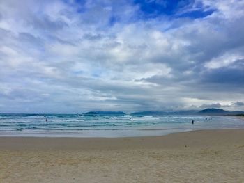 View of beach against cloudy sky