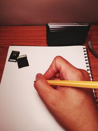 Close-up of hand using smart phone on table